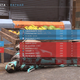 Un soldat spartiate dort par terre devant la charrette de fruits à Bazaar dans Halo Infinite.